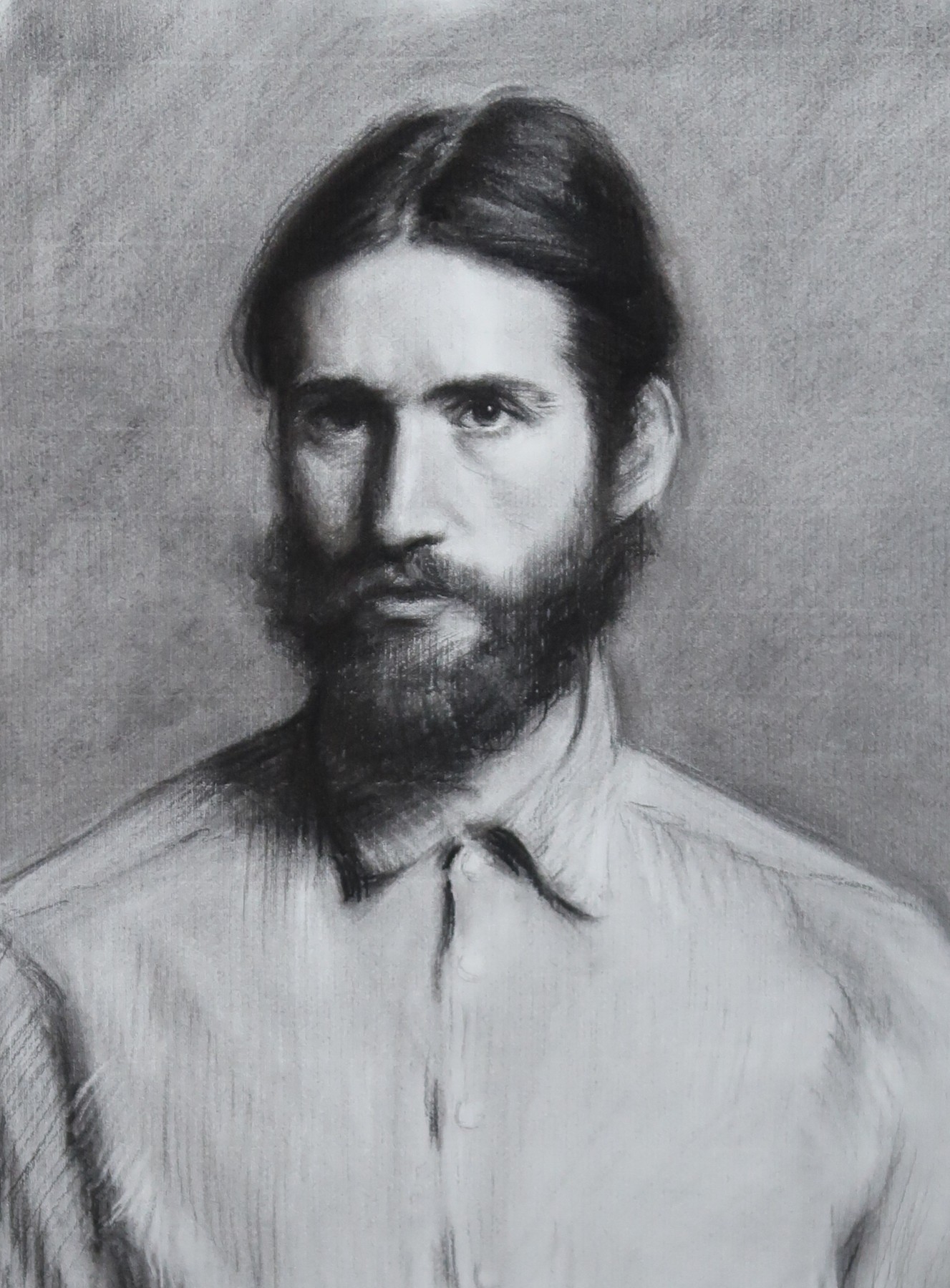 Charcoal portrait of a bearded man in a light shirt