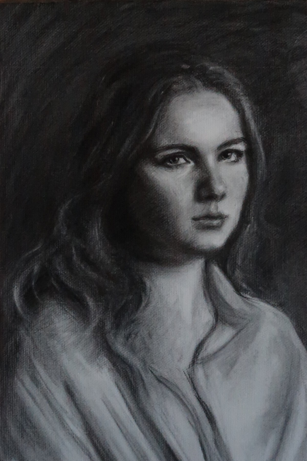 Charcoal portrait of a woman with long hair in a light shirt