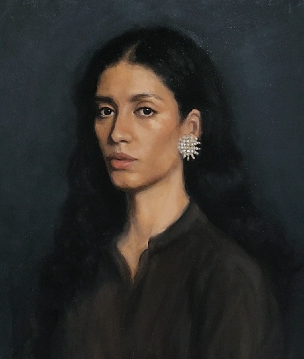 Portrait of a dark-haired woman with a flower-shaped earring